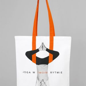 Biała, bawełniana torba z widoczną kobietą w pozycji jogowej, widoczny napis Joga w twoim rytmie z pomarańczowymi uszami wszytymi w torbę
