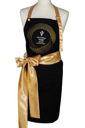 Fartuch gastronomiczny bawełniany czarny ze złotą szarfą i nadrukiem logo Victoria Vynn Salon Partnerski